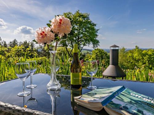 a table with glasses and a bottle of wine and flowers at 3 Bed in Lydbrook 94490 in Lydbrook