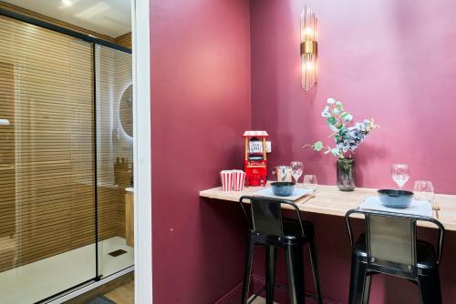 a pink room with a table and two chairs at Le Cinema - Les Demeures d'Adrien in Armentières