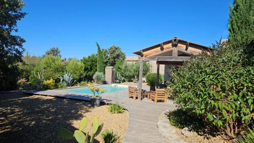une arrière-cour avec une piscine et un pavillon dans l'établissement Roulotte domaine Farigoule, à Baron