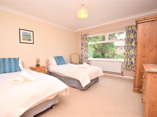 a bedroom with two beds and a window at 4 Bed in Cromer KT116 in Cromer