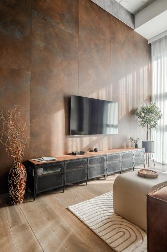 a living room with a large television on a wall at Rusty Wave Loft in Central Klaipeda in Klaipėda