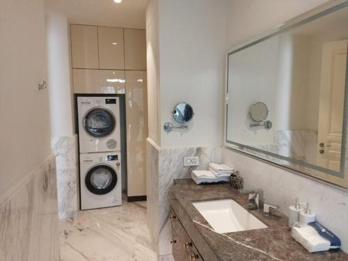 a bathroom with a sink and a washing machine at Leela Lifestyle Apartment in Bangalore in Bengaluru