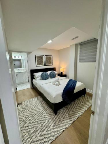 een slaapkamer met een groot bed met blauwe kussens bij 2 BR Private Basement Suite | Minutes from YYZ in Brampton