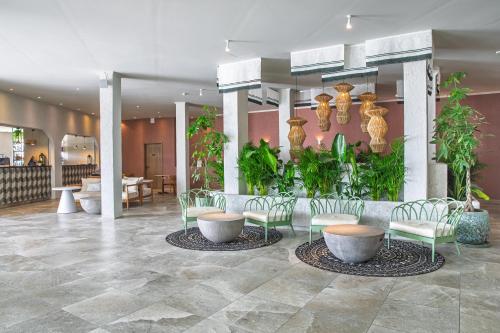 a lobby with chairs and plants in a building at Mangia's Sardinia Resort - NEW OPENING in Santa Teresa Gallura