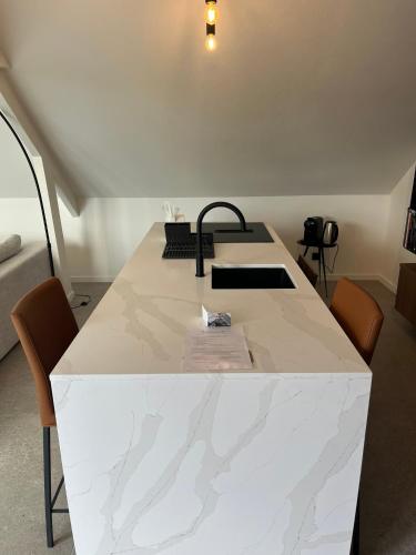 a white marble table with chairs in a room at Business Accommodation 'Loft' Intimate in Geel