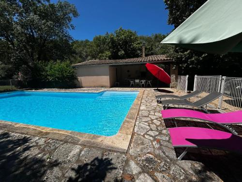 - une piscine avec des chaises et un parasol rouge dans l'établissement Villa historique à Berrias-et-Casteljau, 350 m² avec piscine privée, à Berrias Et Casteljau