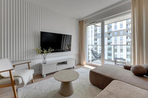 ein Wohnzimmer mit Sofa und Fernseher in der Unterkunft Horizon 63 Superior by Grand Apartments in Danzig