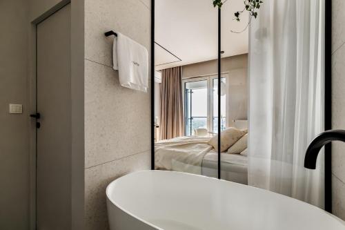 a bathroom with a bath tub and a bedroom at Bathtub and View 21st Floor The WAW Sawa in Skorka