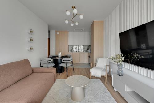 ein Wohnzimmer mit Couch und ein Esszimmer in der Unterkunft Horizon 63 Superior by Grand Apartments in Danzig