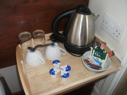 a tea kettle sitting on top of a wooden counter top at Edinburgh House Hotel in Edinburgh
