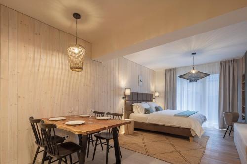 a bedroom with a bed and a table and chairs at Apartmány Hraničná s privátním wellness in Bedřichov