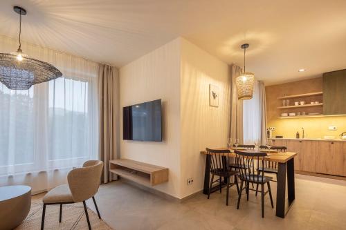 a kitchen and dining room with a table and chairs at Apartmány Hraničná s privátním wellness in Bedřichov