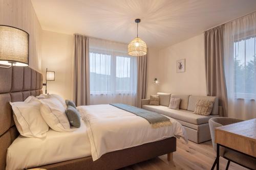 a bedroom with a large bed and a couch at Apartmány Hraničná s privátním wellness in Bedřichov