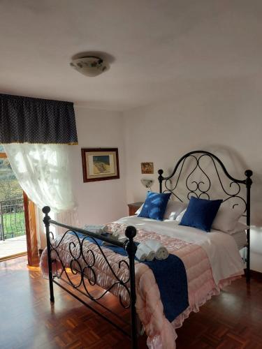a bedroom with a bed with blue pillows at L'Antica Sosta Affittacamere in Colle Umberto