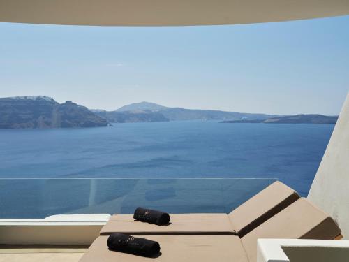 a view of the water from the balcony of a house at Andronis Luxury Suites in Oia