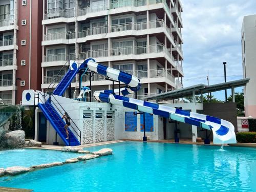 a water slide in a swimming pool in front of a building at Grandblue Condominium#702 Seaview TopFloor MaePhim Rayong in Mae Pim