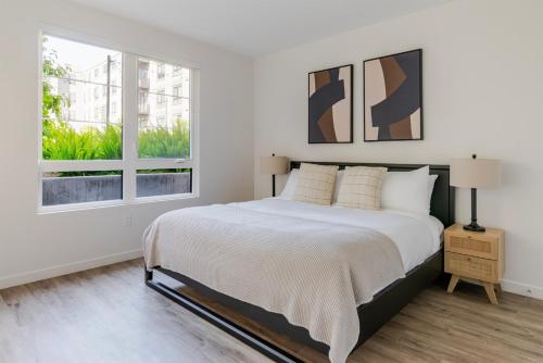 ein weißes Schlafzimmer mit einem großen Bett und einem Fenster in der Unterkunft Blueground Santa Clara washer nr Central Park SFO-1880 in Santa Clara