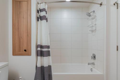 ein Badezimmer mit Dusche mit schwarz-weißem Duschvorhang in der Unterkunft Blueground Santa Clara washer nr Central Park SFO-1880 in Santa Clara