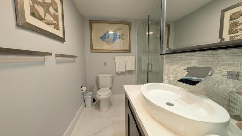 a white bathroom with a sink and a toilet at Inn On The Drive in Fort Lauderdale