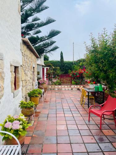 a patio with a table and chairs and plants at Alto Paraíso Boutique Hotel in Reguengo Grande