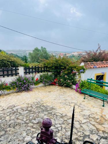 a fire hydrant in a yard with a bench and flowers at Alto Paraíso Boutique Hotel in Reguengo Grande
