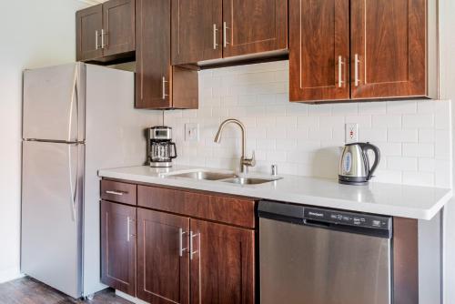 a kitchen with wooden cabinets and a stainless steel refrigerator at Blueground Campbell pool nr Campbell Park SFO-1889 in Campbell