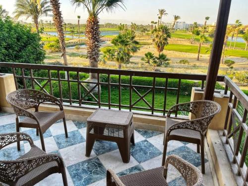 a balcony with chairs and tables and a view of a field at 3-BR Duplex - Near Beach & Hotel in Einbay l Wifi in Ain Sokhna
