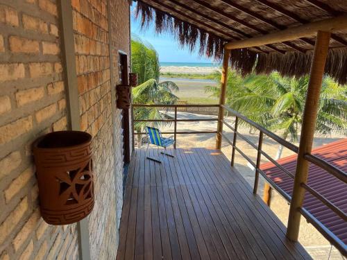 eine Veranda eines Hauses mit einem Eimer und einem Stuhl in der Unterkunft Casa Farol - Praia de Itarema, CE in Itarema