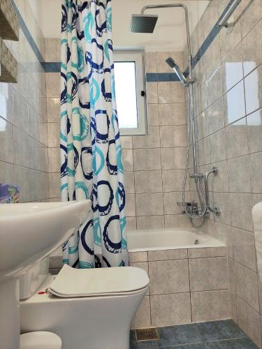 a bathroom with a toilet and a shower curtain at Louis' apartment with view in Gythio