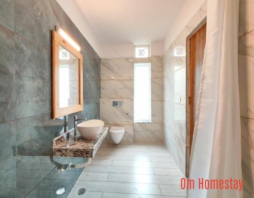 a bathroom with a sink and a toilet in it at Om Homestay in Rishīkesh