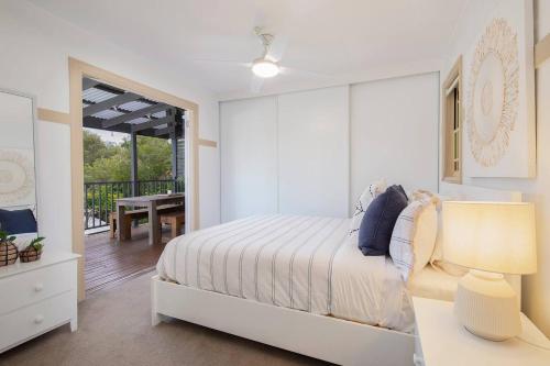 a bedroom with a bed and a table with a lamp at The Lake Haus - Spacious Waterfront Escape with Pool in Karraganbah