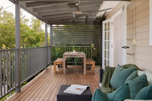a patio with a couch and a table on a deck at The Lake Haus - Spacious Waterfront Escape with Pool in Karraganbah