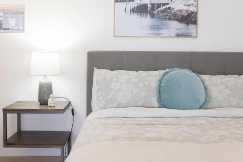 a bedroom with a bed with a blue pillow and a side table at The Lake Haus - Spacious Waterfront Escape with Pool in Karraganbah