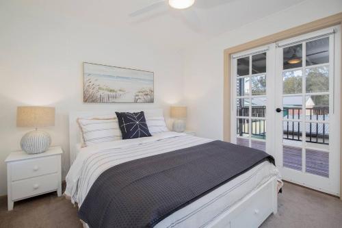 a bedroom with a large bed and a window at The Lake Haus - Spacious Waterfront Escape with Pool in Karraganbah