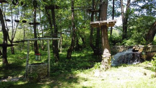 a forest with a bird house and a waterfall at Moara Viselor in Vaideeni