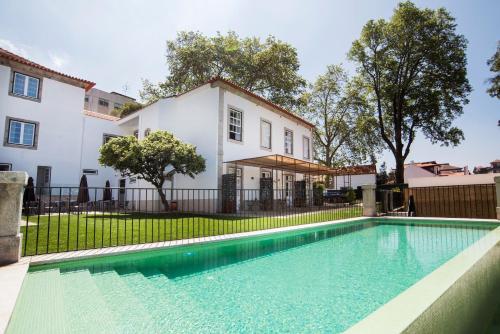 a swimming pool in front of a house at bnapartments Carregal in Porto