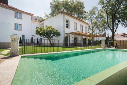a swimming pool in front of a house at bnapartments Carregal in Porto