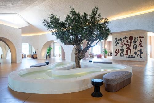 a tree in the middle of a room with a building at Mangia's Sardinia Resort - NEW OPENING in Santa Teresa Gallura