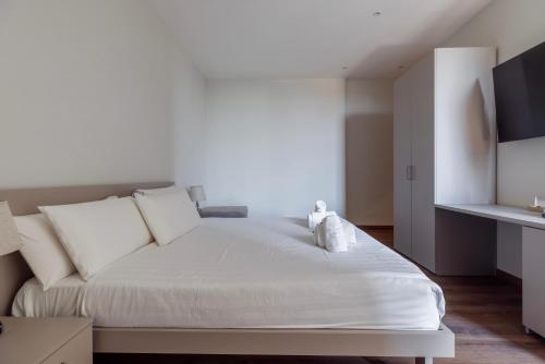 ein Schlafzimmer mit einem weißen Bett mit weißen Kissen in der Unterkunft Vatican Pertusa Luxury Suites by Quinto Piano in Rom