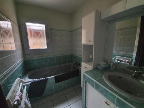 une salle de bain avec une baignoire et un lavabo dans l'établissement CARCANS MAUBUISSON LOCATION SAISONNIERE VILLA 6 couchages, à Carcans