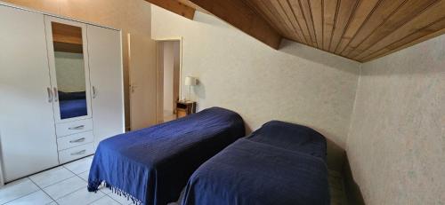 une chambre avec deux lits et un plafond en bois dans l'établissement CARCANS MAUBUISSON LOCATION SAISONNIERE VILLA 6 couchages, à Carcans