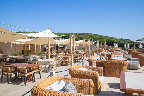 a patio with chairs and tables and umbrellas at Mangia's Sardinia Resort - NEW OPENING in Santa Teresa Gallura
