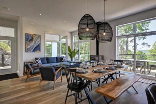 a living room with a table and a blue couch at Kensho Enjoy nature life with Hot tub in Sainte Béatrix