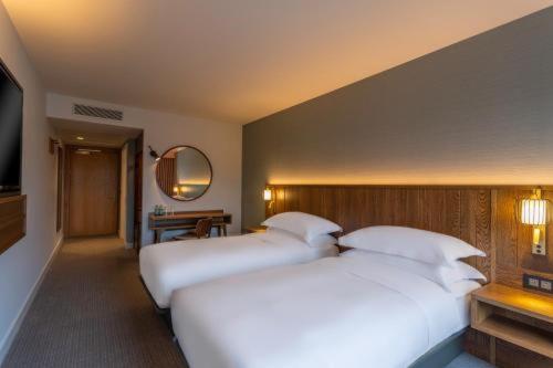 a hotel room with two beds and a television at Hotel De Gross infinity Free convention Centre Drop in New Delhi