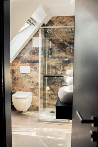 a bathroom with a glass shower and a toilet at Hotel Heidelux in Soltau