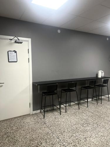 a meeting room with a table and chairs against a wall at Rentalux Hostel - Modern Comfort, Single Rooms in Timrå