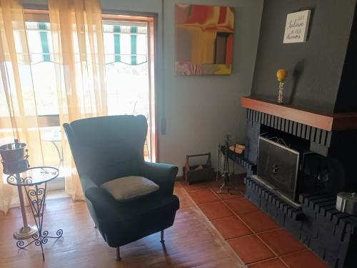 a living room with a chair and a fireplace at Coffee Cream Guest House Maia in Maia