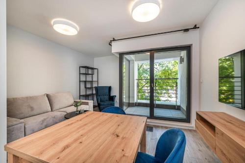 a living room with a wooden table and a couch at GDYNIA CENTRUM - Blisko plaży in Gdynia
