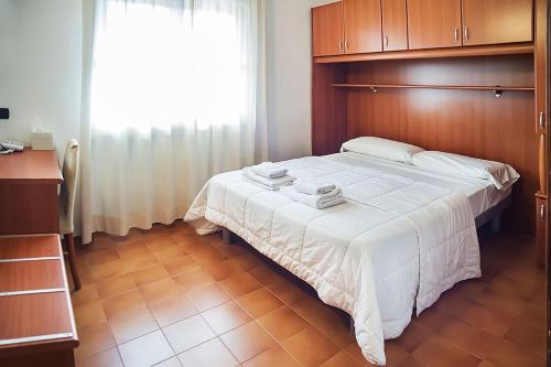a bedroom with a large bed with a wooden headboard at Hotel Il Castello in Pozzolengo