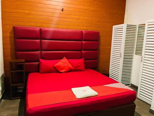 a red bed with a red headboard in a room at New Kings Gate Airport Transit Hotel in Katunayake